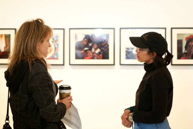 Two people talk in front of artwork